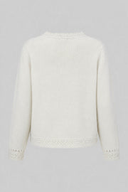 A delicate buttoned cardigan made of ecru alpaca wool and girl's wool.