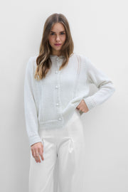 A delicate buttoned cardigan made of ecru alpaca wool and girl's wool.