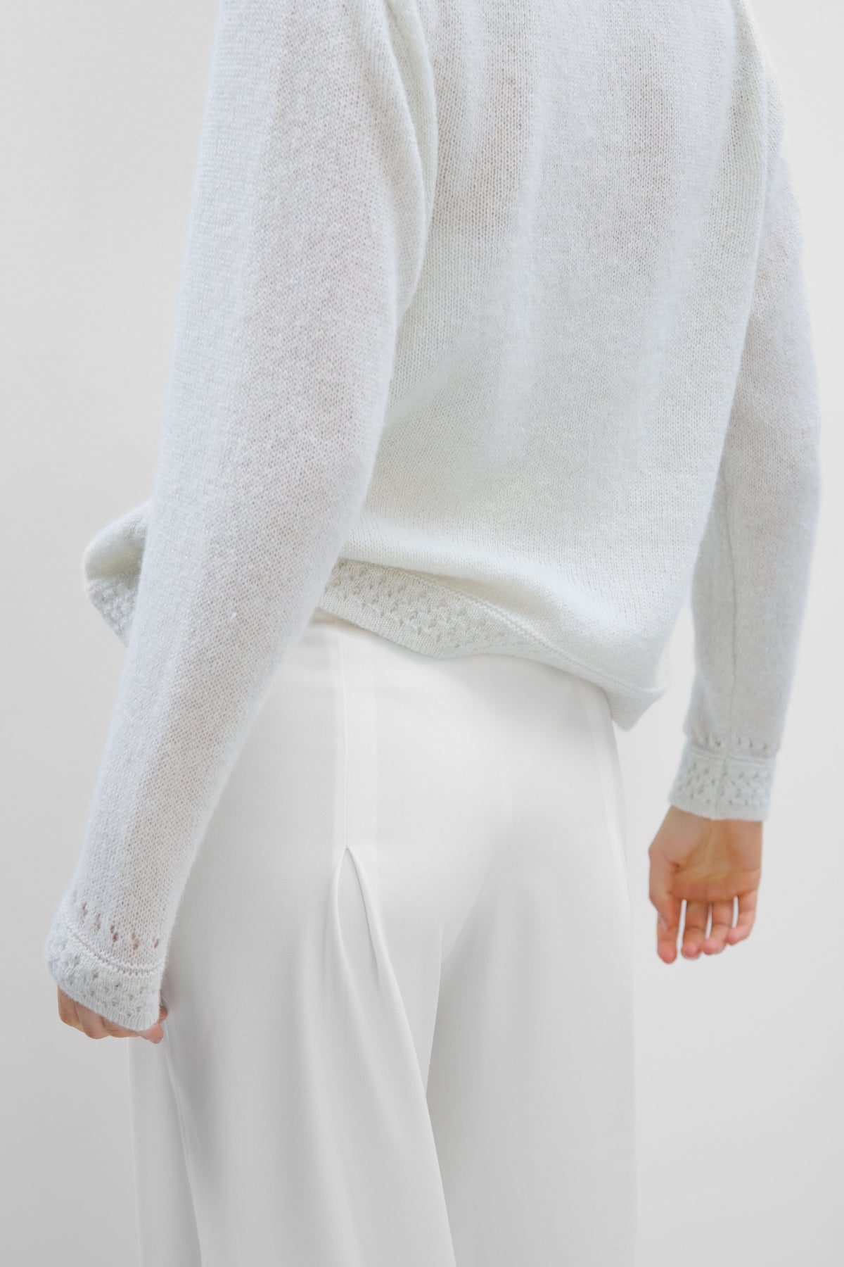 A delicate buttoned cardigan made of ecru alpaca wool and girl's wool.