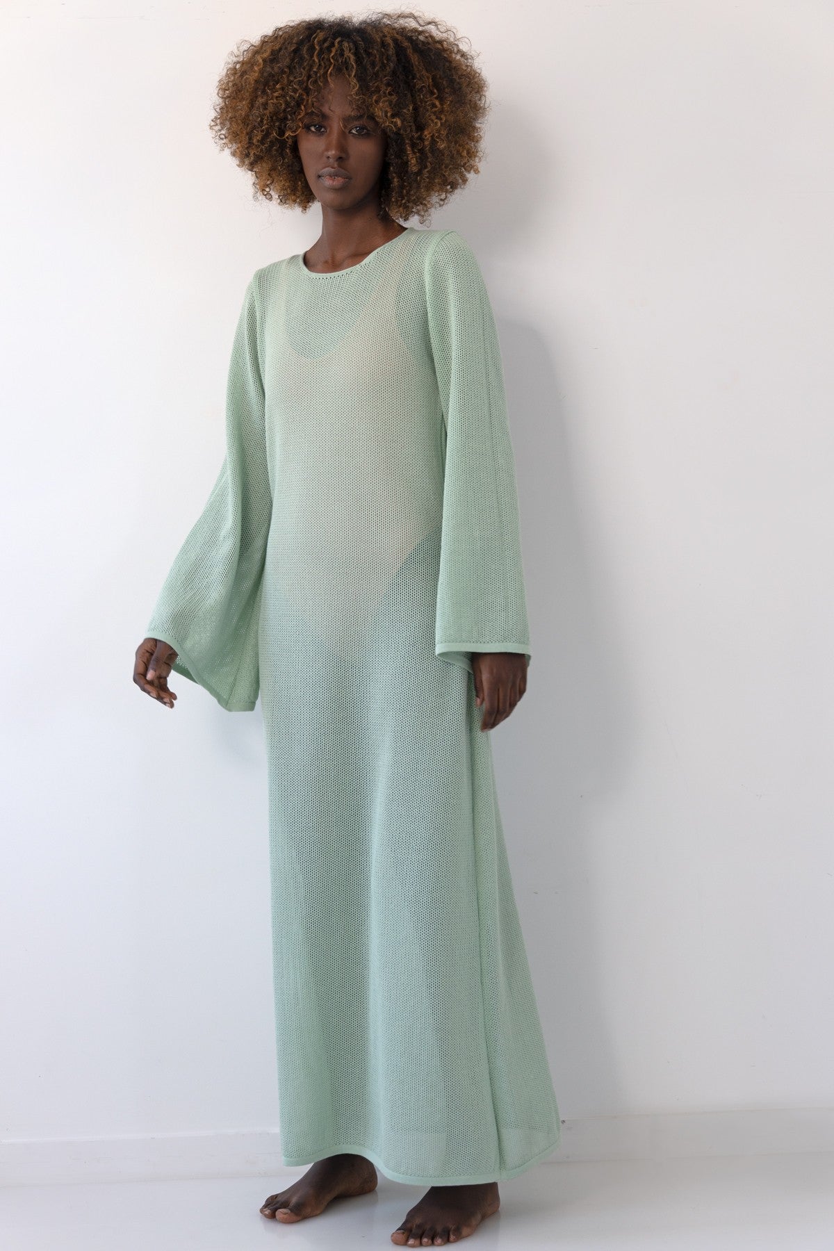 Long openwork dress with a neckline on the back made of pistachio cotton