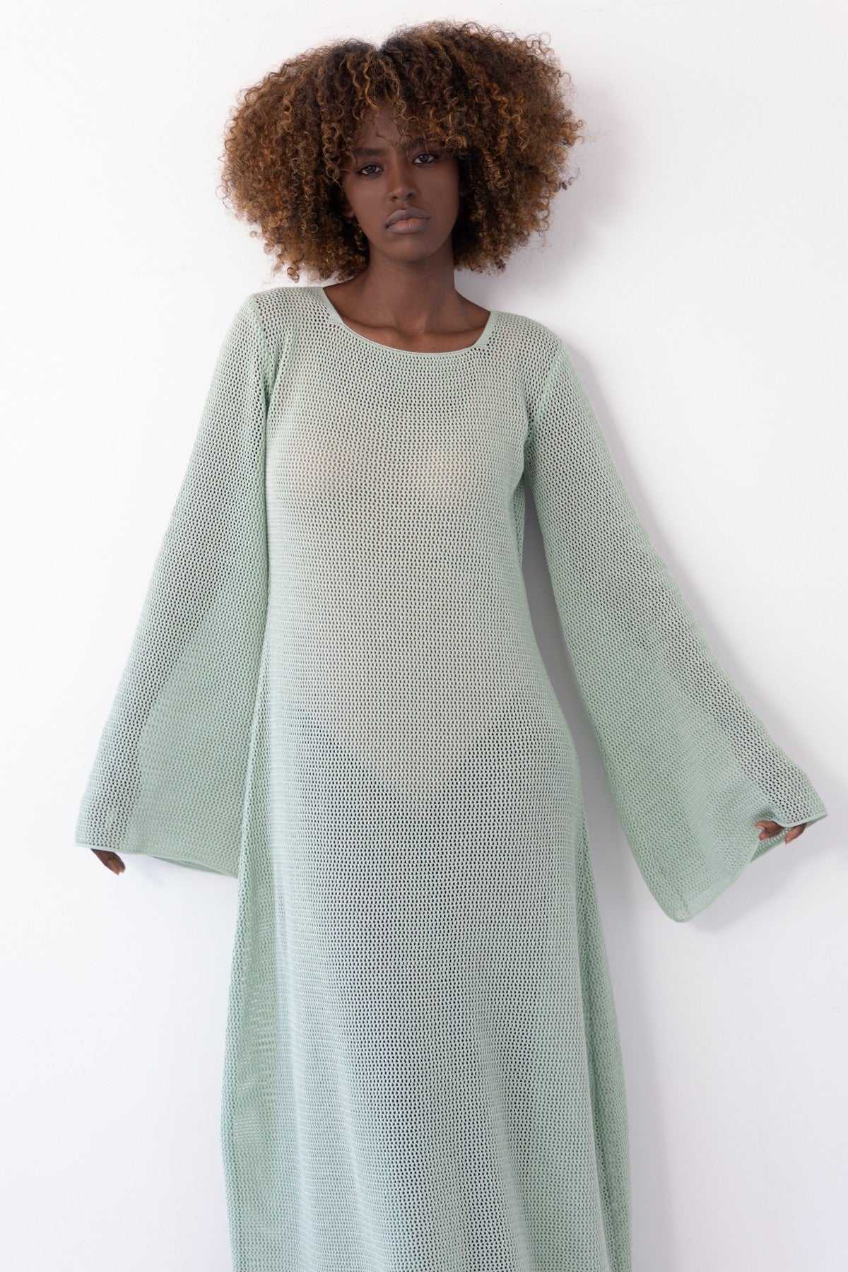 Long openwork dress with a neckline on the back made of pistachio cotton
