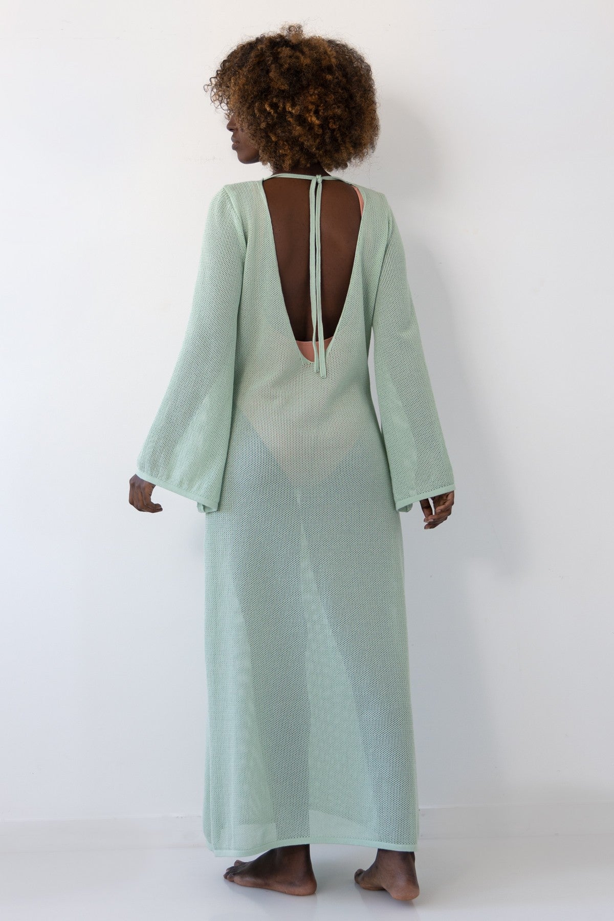 Long openwork dress with a neckline on the back made of pistachio cotton