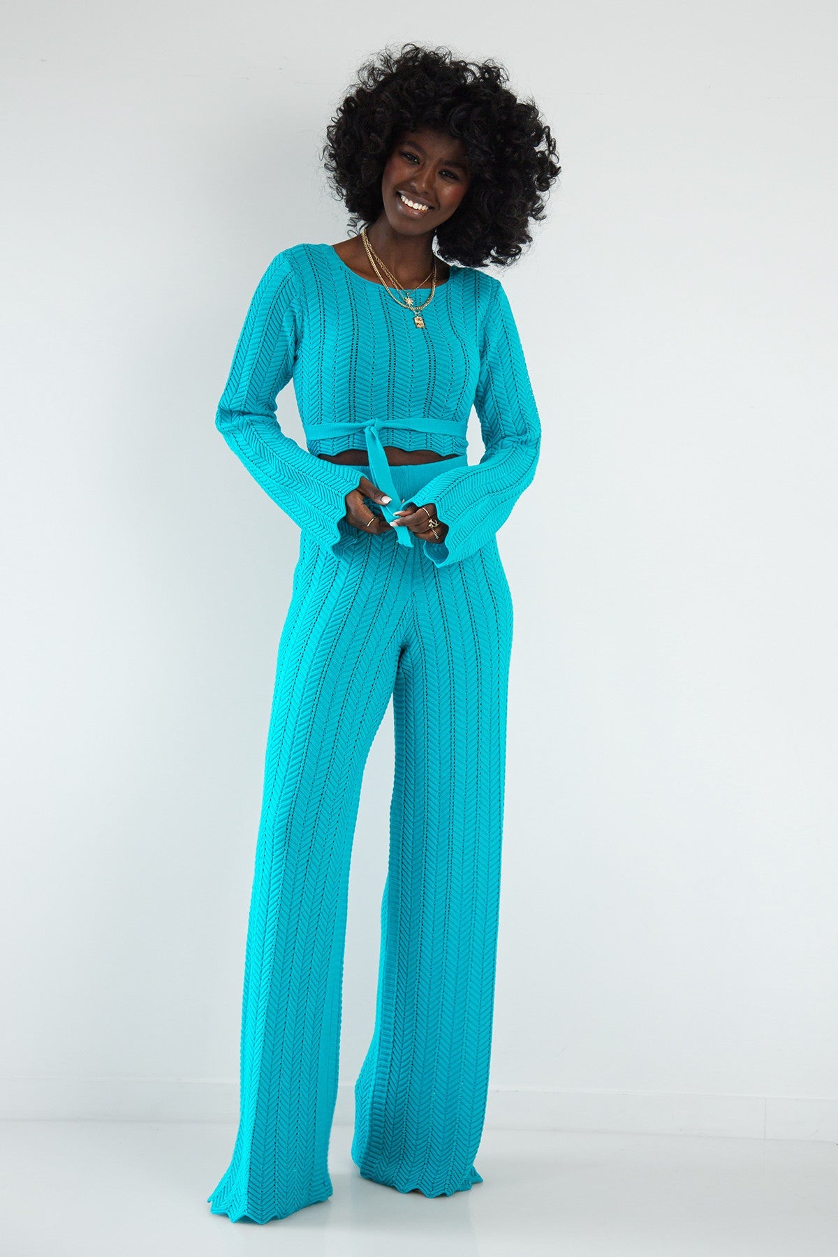 Set of long openwork trousers and a tied blouse in blue